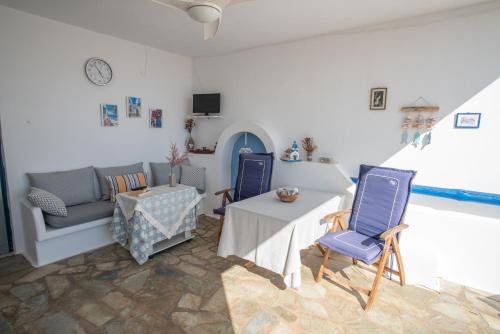 a living room with a table and blue chairs at MARKOS' HOUSE in Agiassos