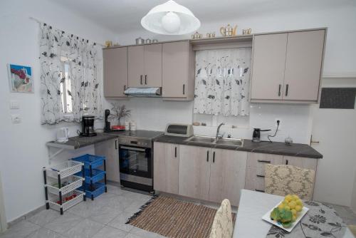 a kitchen with white cabinets and a sink at MARKOS' HOUSE in Agiassos