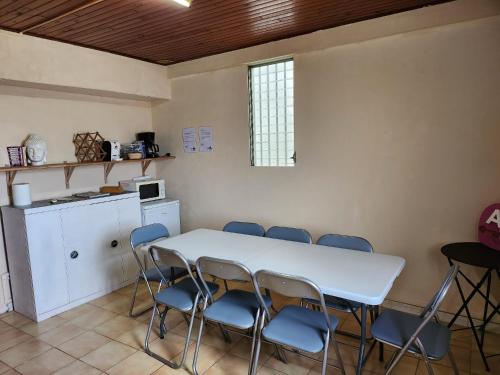 Zimmer mit einem Tisch und Stühlen sowie einer Küche in der Unterkunft Refuge étape du baroudeur in Le Carbet