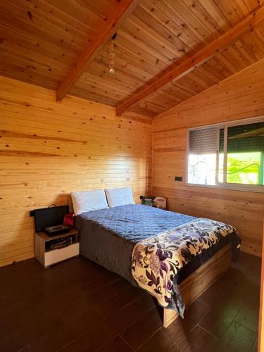 1 dormitorio con 1 cama en una habitación de madera en Charmant Chalet calme et moderne en Dar Mohammed Ould Haj Jilali
