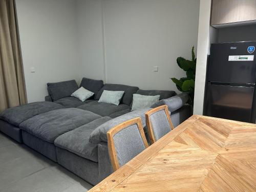 WelcomeHome Apartments Aljada في الشارقة: غرفة معيشة مع أريكة وطاولة