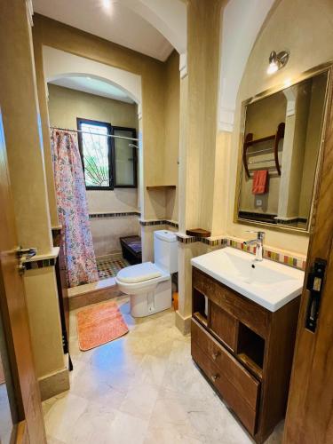 a bathroom with a sink and a toilet and a mirror at Entire villa with private pool in Marrakech in Marrakesh