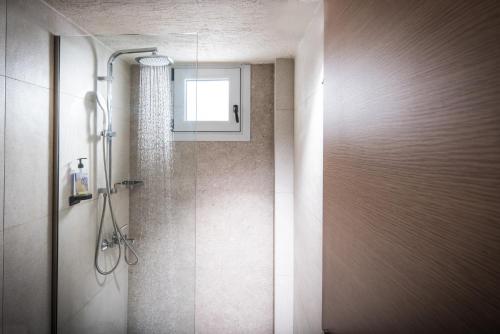 een badkamer met een douche en een raam bij South Coast in Makry Gialos