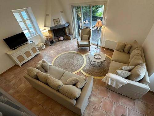a living room with a couch and a fireplace at Magnifique mas provençal avec piscine au centre de Goudargues in Goudargues