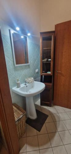 a bathroom with a white sink and a mirror at Casa Nicole in Assemini