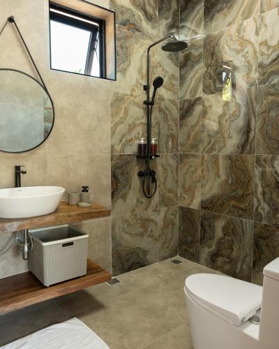 a bathroom with a sink toilet and a mirror at SHI Phangan Villas in Hinkong