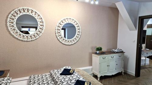 a bedroom with two mirrors and a bed and a dresser at APARTAMENT JARACZA 28 nr 18 in Słupsk