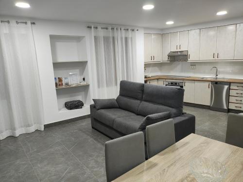 salon z kanapą i kuchnią w obiekcie Casa del Castillo w mieście Caravaca de la Cruz