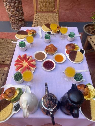 una mesa con comida para el desayuno y bebidas en ella en Riad Nkob, en Nkob