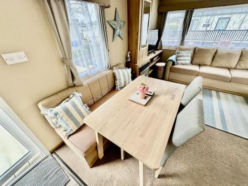 Everton的住宿－Coastal Retreat a gorgeous 3 bedroom Caravan B46，小型客厅配有木桌和椅子
