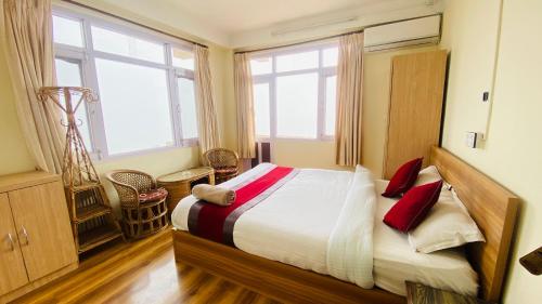 a bedroom with a bed with red pillows on it at Himalayan Sunrise in Dhulikhel