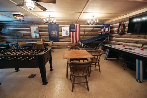 Five CornersにあるRoyal Stag Ausableの卓球台、椅子、旗が備わる客室です。