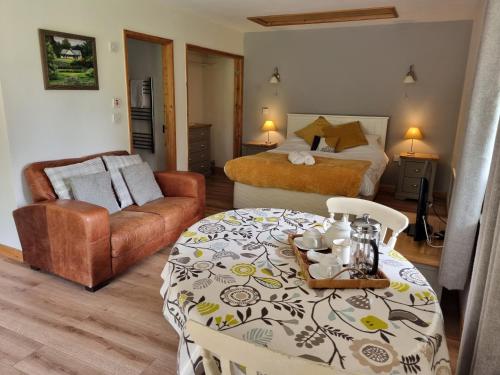 1 dormitorio con cama, mesa y sofá en Glyndwr Vineyard, en Cowbridge