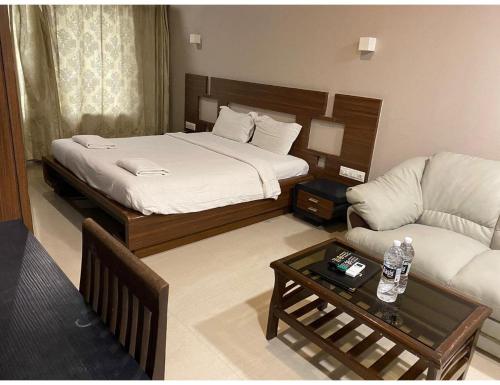 a hotel room with a bed and a couch at Hotel Rishivan Resort, Khopoli in Khopoli