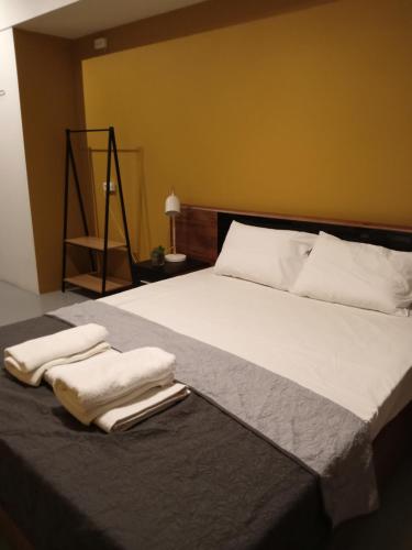 1 dormitorio con 1 cama grande y 2 toallas. en Central Hostel, en Atenas