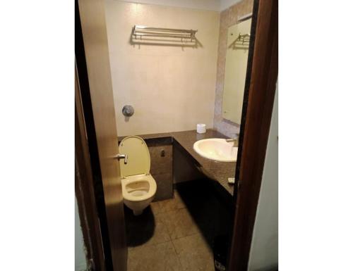 a bathroom with a toilet and a sink at Hotel Rishivan Resort, Khopoli in Khopoli