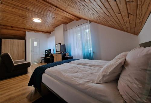 a bedroom with a large bed with a wooden ceiling at Dom Gościnny Dżafar Pogorzelica in Pogorzelica