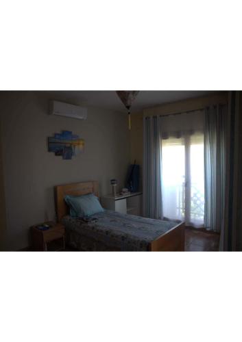 a small bedroom with a bed and a window at Marinazur in Saidia 