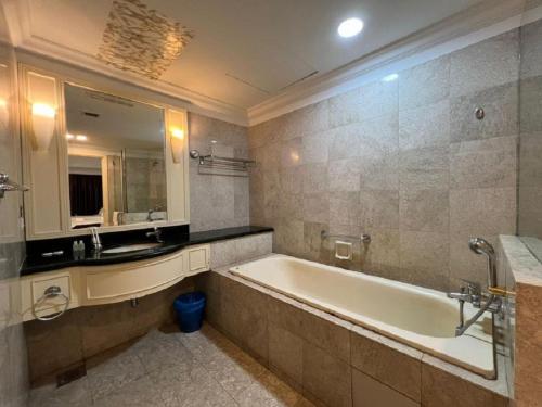 a bathroom with a tub and a sink and a mirror at RESORT SUITES AT BARJAYA TIMES SQUARE kL in Kuala Lumpur