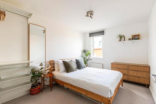 Schlafzimmer mit einem Bett und einem Spiegel in der Unterkunft Urban and Stylish Apartment in London
