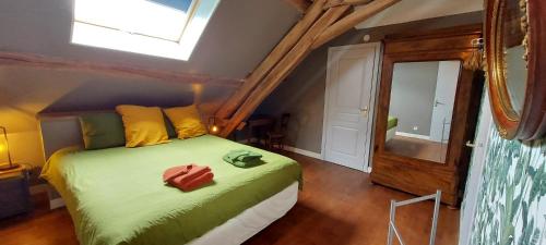 a bedroom with a green bed with a window at B&B Bon Vivant in Brinay