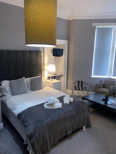 a bedroom with a large bed with towels on it at Ellwyn House in Edinburgh
