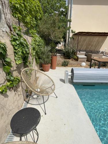 une chaise et une table à côté de la piscine dans l'établissement La Feuilleraie, à Montséret