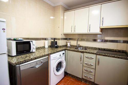 kuchnia z kuchenką mikrofalową, pralką i suszarką w obiekcie RentalSevilla Apartamento encantador en el Gran Poder w Sewilli