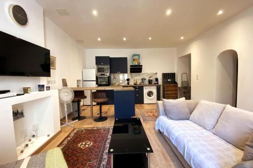 un salon avec un canapé blanc et une cuisine dans l'établissement ''Ninou'' Cosy T2 en plein coeur de Sète, à Sète