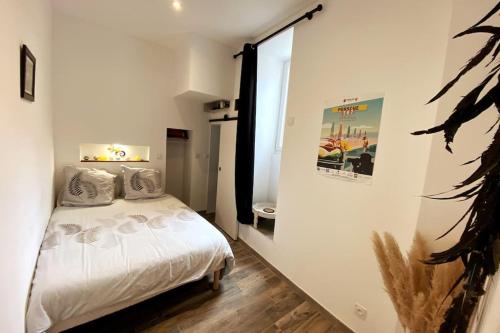 une chambre avec un lit blanc et une fenêtre dans l'établissement ''Ninou'' Cosy T2 en plein coeur de Sète, à Sète