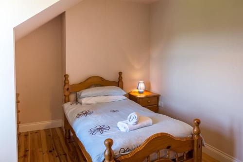 a small bedroom with a bed with towels on it at Ballinakill Lodge in Moyard