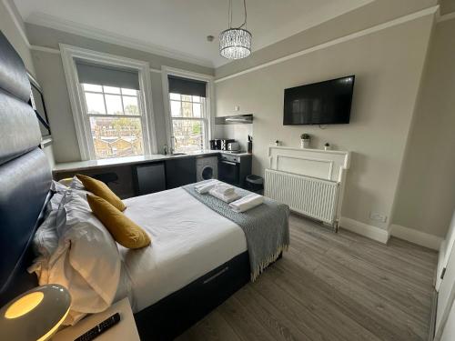 Il comprend une chambre avec un grand lit et une cuisine. dans l'établissement Apartments in the Heart of High Street Kensington, à Londres