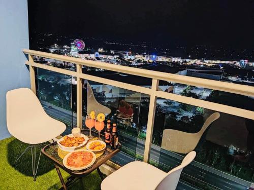 a table with food and drinks on a balcony at Elitista Chateau Azure North Pampanga in San Fernando
