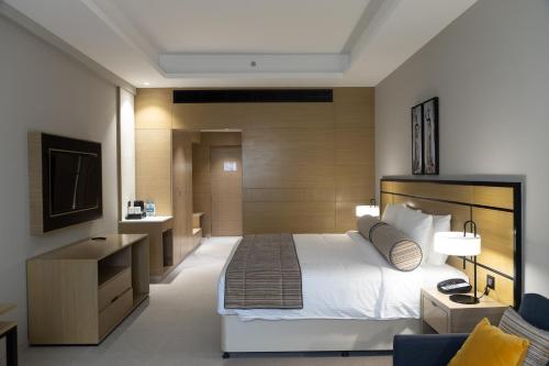 Habitación de hotel con cama y TV en Djibouti Ayla Grand Hotel en Yibuti