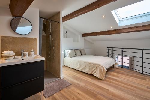a bedroom with a bed and a sink and a mirror at Le rempart Scandinave - Triplex au pied de la Cité in Carcassonne