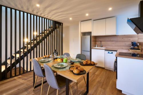une cuisine et une salle à manger avec une table et de la nourriture. dans l'établissement Le rempart Scandinave - Triplex au pied de la Cité, à Carcassonne