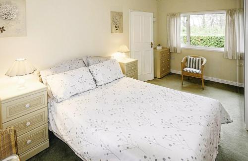 1 dormitorio con cama blanca y ventana en Pines Cleeve Park, en Blue Anchor
