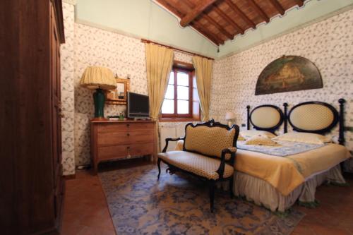 una camera con letto, sedia e televisore di Luxury Villa with pool by Varental a Melezzole