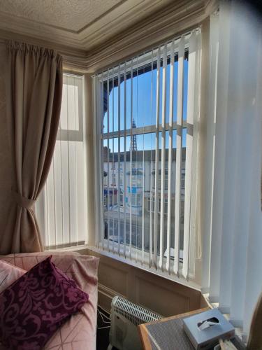 a bedroom with a window with a view of a city at Windsor House Hotel in Blackpool