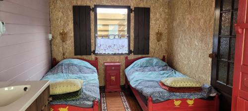 two beds in a room with a sink and a bathroom at Op e Mieden in Bartlehiem