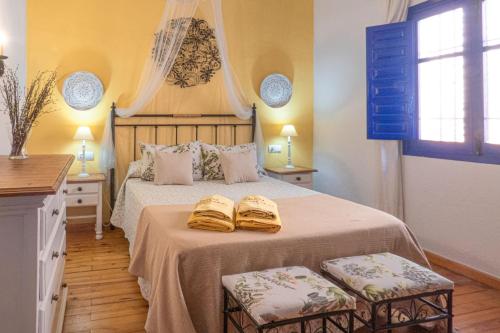 a bedroom with a bed with two towels on it at Cortijo Fernando in Frigiliana