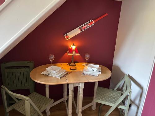a table with wine glasses and a baseball bat on it at Sticky Wicket by Spires Accommodation a comfortable place to stay in Swadlincote in Church Gresley