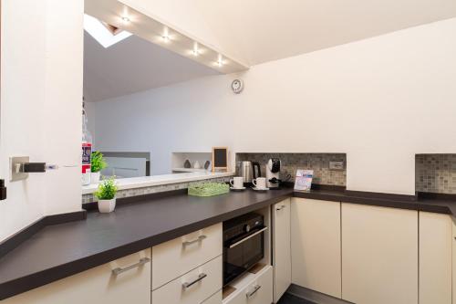 a kitchen with white cabinets and black counter tops at Il camino felice - 201 Autodromo F1 & Villa Reale in Monza