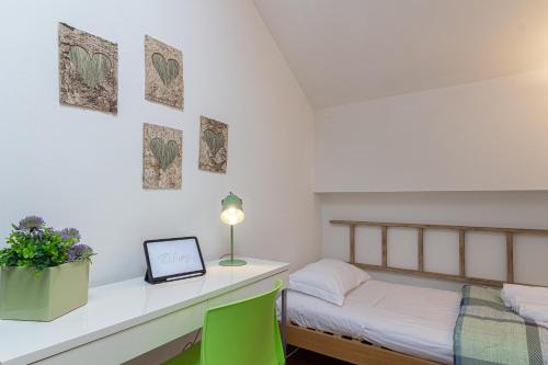 a bedroom with a bed and a desk with a laptop at il camino felice - 201 Autodromo F1 & Villa Reale in Monza