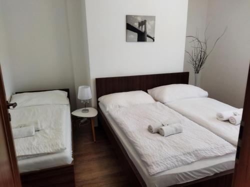 two beds in a room with white sheets and towels at Topolský pivovar, restaurace a penzion in Topolná