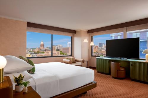 a hotel room with a large bed and a flat screen tv at Downright Austin, A Renaissance Hotel - New Hotel in Austin