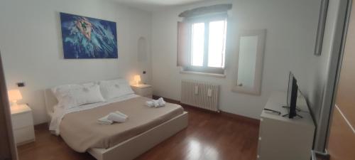 a white bedroom with a bed and a window at Casa Vacanze Angelo in Ortona