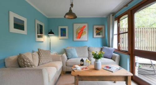 a living room with a couch and a table at Rebels Retreat - 2-Bed Chalet nr St Ives & Hayle in St Ives