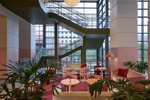 a lobby with tables and chairs and a staircase at Downright Austin, A Renaissance Hotel - New Hotel in Austin