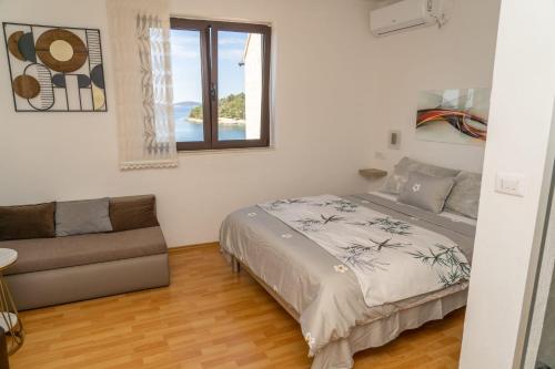 a bedroom with a bed and a couch at Apartments Caric in Hvar